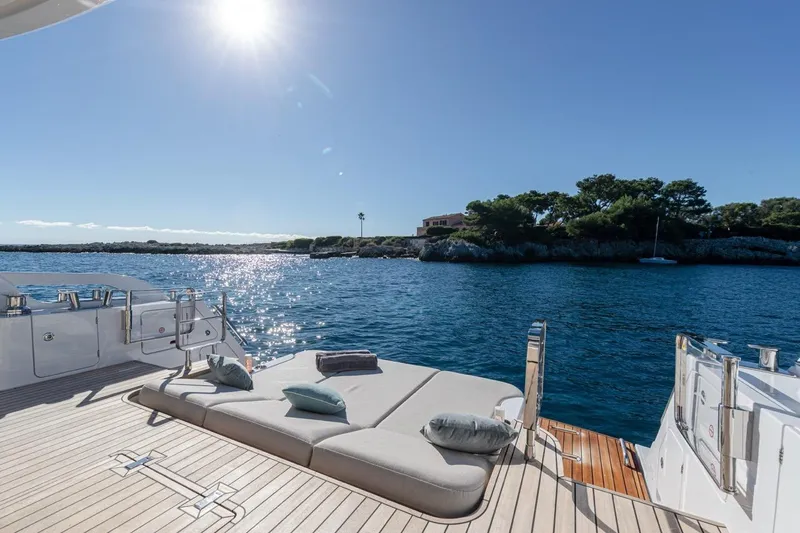  Yacht Photos Pics Luxurious Azimut Fly 62 yacht deck with sun loungers, ocean view, and clear blue sky.