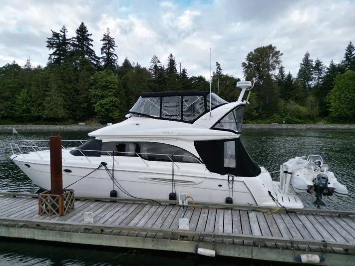 Diamonds Wild Yacht Photos Pics 2006 Meridian 411 Sedan yacht docked by a serene forested shoreline.