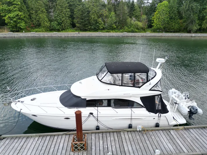 Diamonds Wild Yacht Photos Pics 2006 Meridian 411 Sedan yacht docked by a serene, tree-lined waterfront.