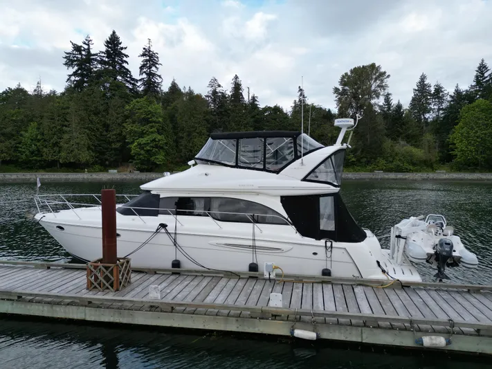 Diamonds Wild Yacht Photos Pics 2006 Meridian 411 Sedan yacht docked by a scenic forested shoreline.