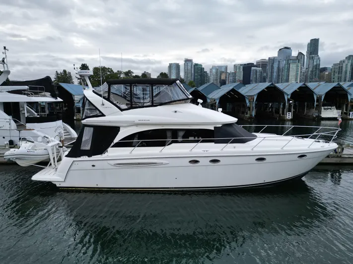 Diamonds Wild Yacht Photos Pics 2006 Meridian 411 Sedan yacht docked in marina with city skyline background.