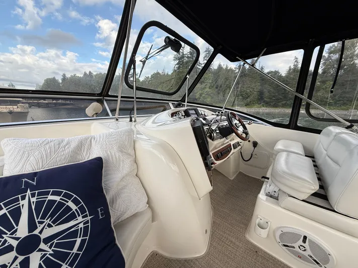 Diamonds Wild Yacht Photos Pics Interior of 2006 Meridian 411 Sedan yacht with helm, white seating, and nautical-themed pillows.