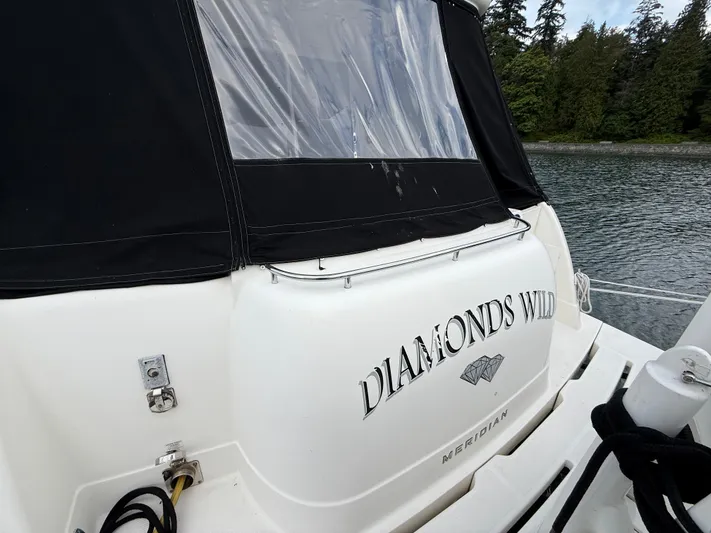 Diamonds Wild Yacht Photos Pics 2006 Meridian 411 Sedan yacht named "Diamonds Wild" docked by a forested shoreline.