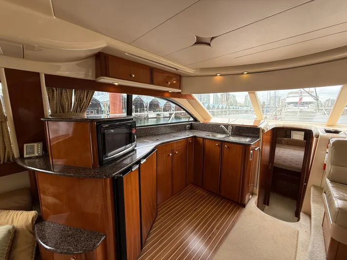 Diamonds Wild Yacht Photos Pics Luxurious interior of a 2006 Meridian 411 Sedan yacht with modern kitchen amenities.
