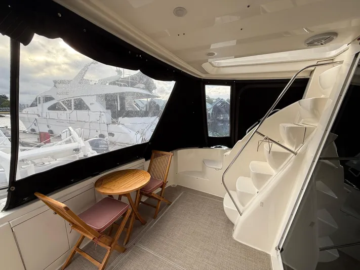 Diamonds Wild Yacht Photos Pics 2006 Meridian 411 Sedan yacht interior with wooden table, chairs, and spiral staircase.