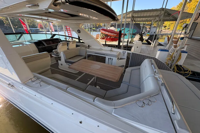  Yacht Photos Pics Luxurious 2023 Sea Ray SLX 400 boat interior with seating and table, docked at marina.