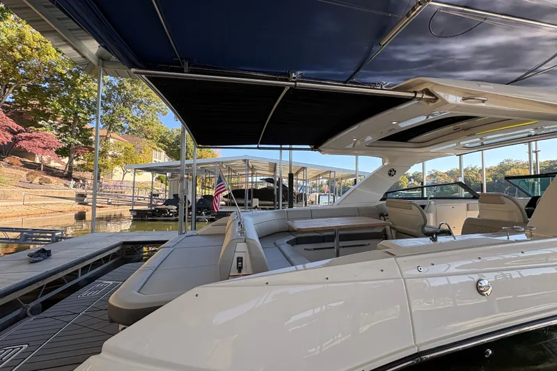  Yacht Photos Pics 2023 Sea Ray SLX 400 luxury boat docked under canopy, showcasing spacious seating area.