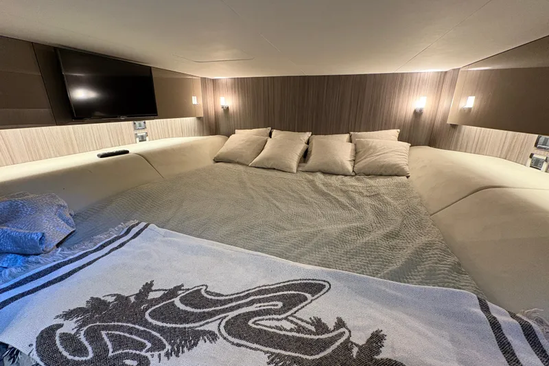  Yacht Photos Pics Luxurious cabin interior of 2023 Sea Ray SLX 400 with cozy bedding and ambient lighting.