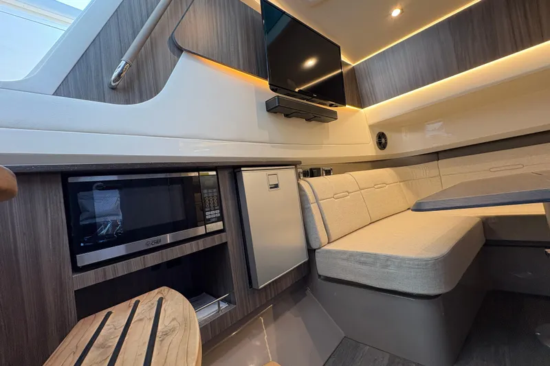  Yacht Photos Pics 2023 Sea Ray SLX 400 cabin interior with seating, TV, microwave, and modern design.