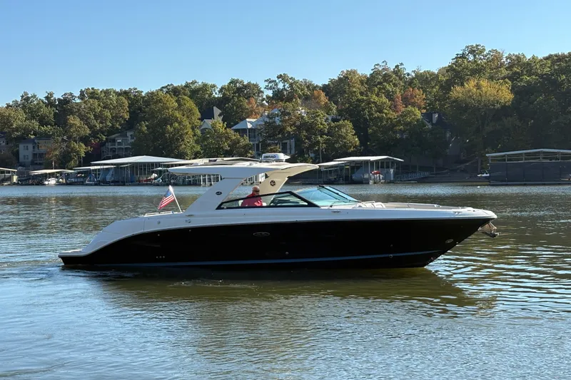  Yacht Photos Pics 2023 Sea Ray SLX 400 boat cruising on a serene lake with lush green shoreline.