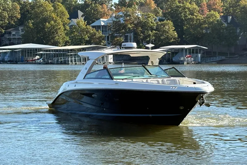  Yacht Photos Pics 2023 Sea Ray SLX 400 boat cruising on a calm lake with trees in the background.