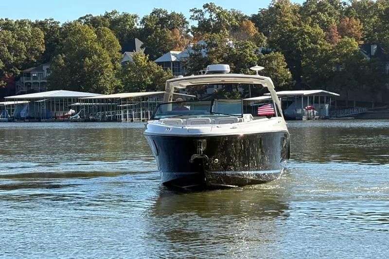  Yacht Photos Pics 2023 Sea Ray SLX 400 boat cruising on a lake with trees and docks in the background.