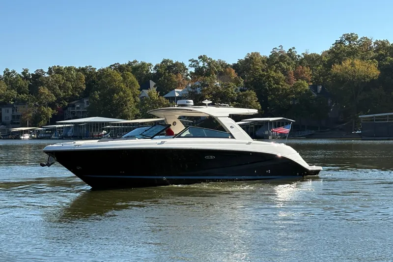  Yacht Photos Pics 2023 Sea Ray SLX 400 boat cruising on a serene lake with lush green trees.