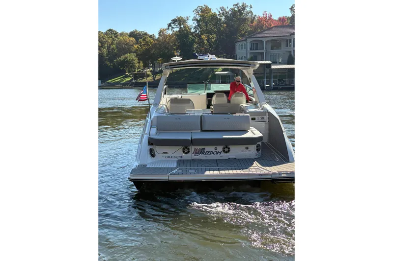  Yacht Photos Pics 2023 Sea Ray SLX 400 boat on a lake, rear view with American flag.