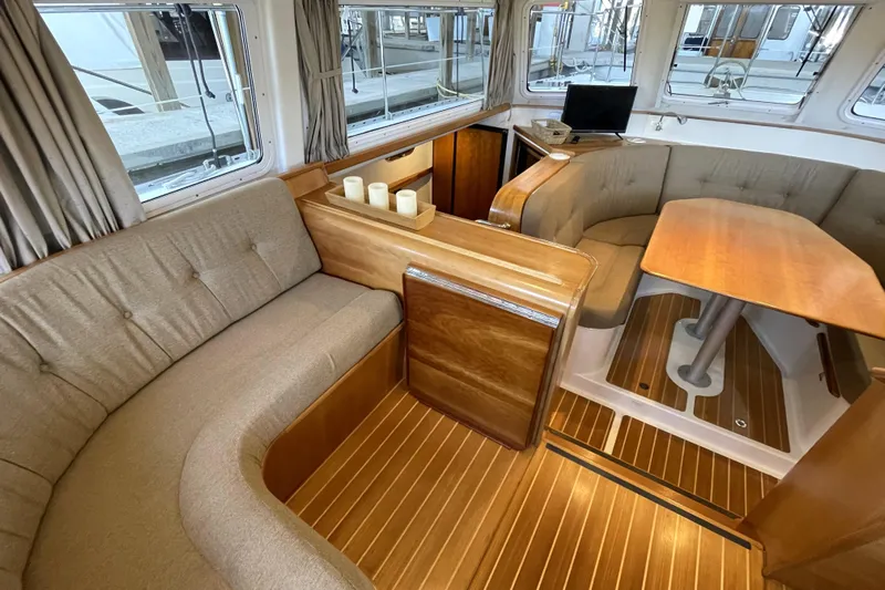 "new Hope" Yacht Photos Pics Interior of 2006 PDQ 34 Power Catamaran with cozy seating and wooden finishes.