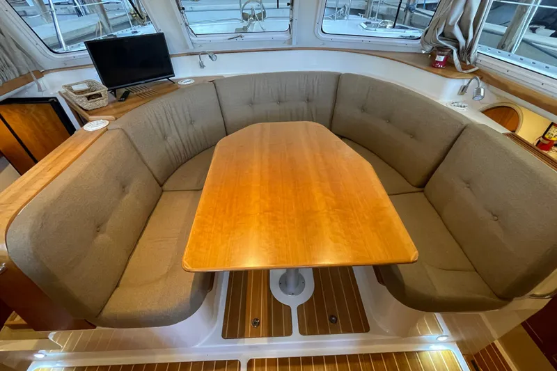 "new Hope" Yacht Photos Pics Interior of 2006 PDQ 34 Power Catamaran with cozy seating and wooden table.