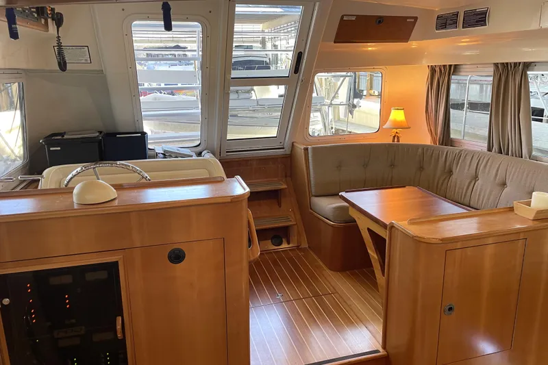 "new Hope" Yacht Photos Pics Interior of 2006 PDQ 34 Power Catamaran with wood finish and cozy seating area.
