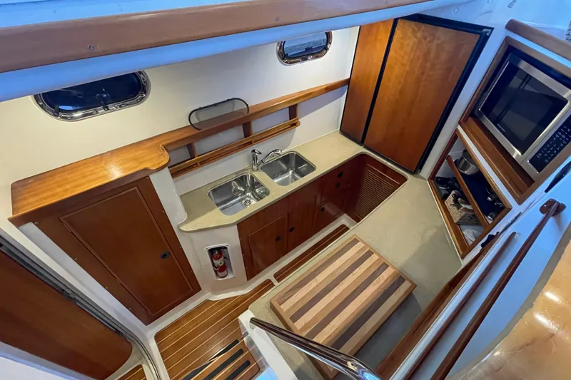 "new Hope" Yacht Photos Pics Interior of 2006 PDQ 34 Power Catamaran, featuring a compact kitchen with wood accents.