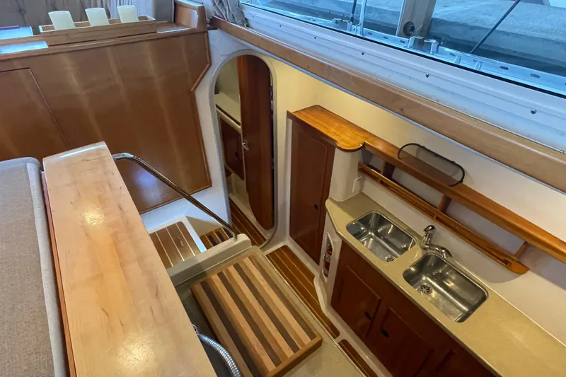 "new Hope" Yacht Photos Pics 2006 PDQ 34 Power Catamaran interior with wooden cabinetry and dual sink kitchen area.