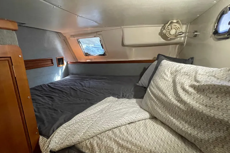 "new Hope" Yacht Photos Pics Cozy cabin interior of 2006 PDQ 34 Power Catamaran with bed and porthole windows.