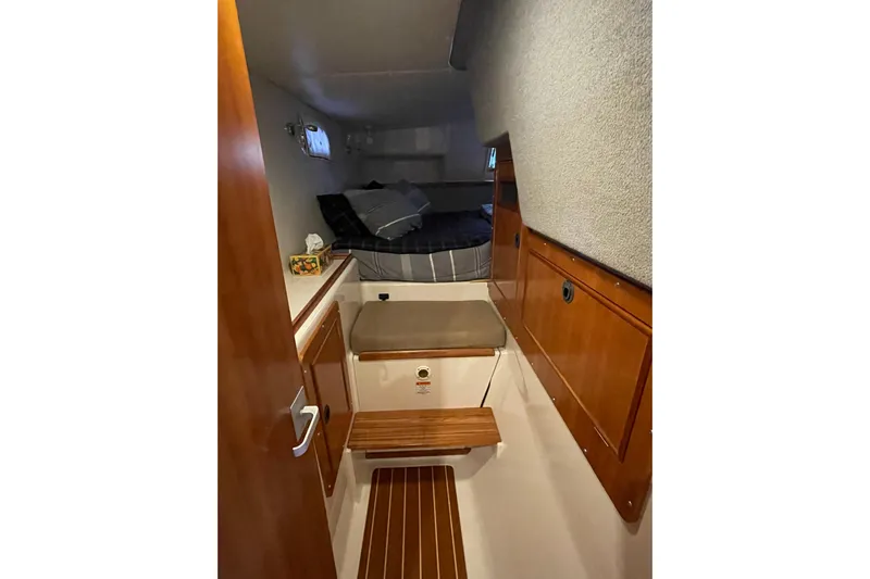 "new Hope" Yacht Photos Pics Interior cabin of 2006 PDQ 34 Power Catamaran with wooden accents and cozy bedding.