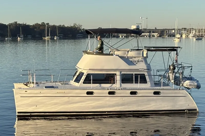 "new Hope" Yacht Photos Pics 2006 PDQ 34 Power Catamaran on calm water, featuring sleek design and spacious deck.