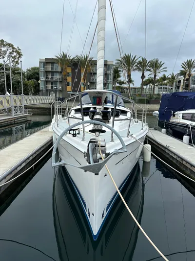 Lanikai Yacht Photos Pics 2007 Hunter 44 Deck Salon sailboat docked in marina, surrounded by palm trees and buildings.
