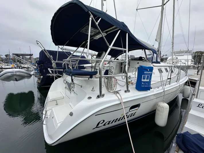 Lanikai Yacht Photos Pics 2007 Hunter 44 Deck Salon sailboat docked in marina, featuring blue canopy and sleek design.