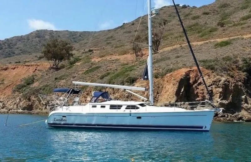 Lanikai Yacht Photos Pics 2007 Hunter 44 Deck Salon sailboat anchored near rocky coastline.