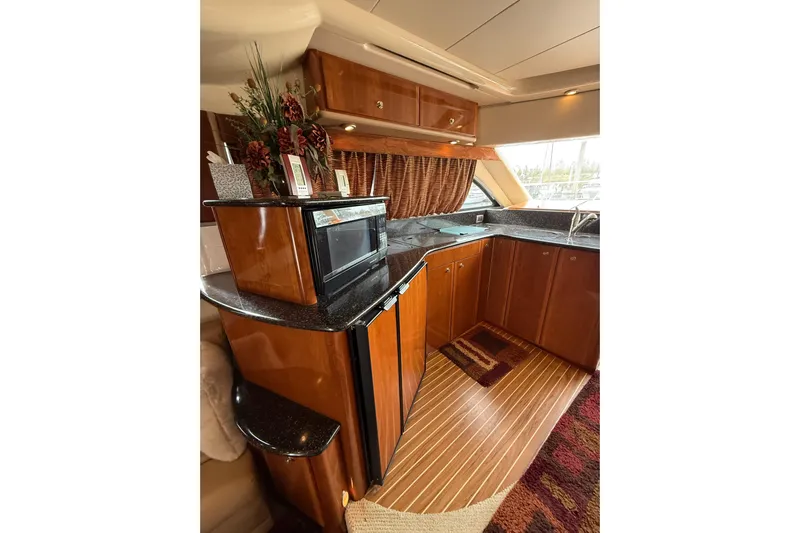 Yacht Photos Pics Luxurious kitchen interior of 2007 Meridian 411 Sedan yacht with wood cabinetry and modern appliances.
