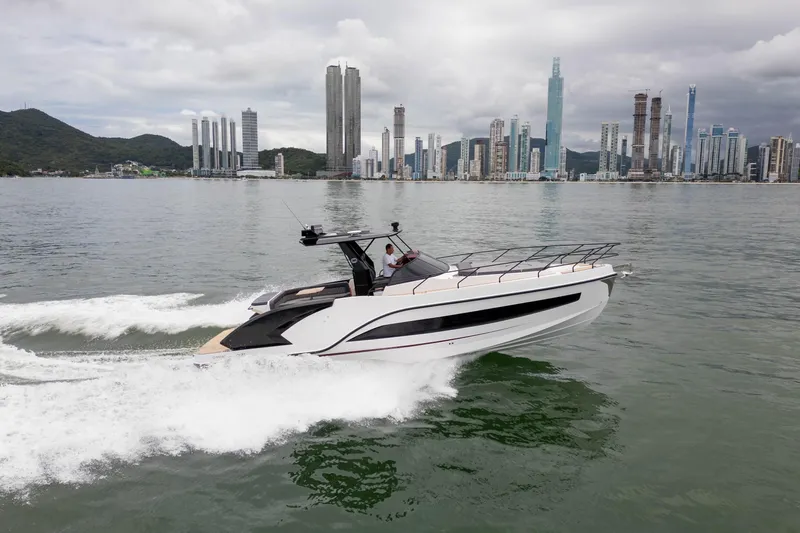  Yacht Photos Pics 2026 GRAND OCEAN 37 yacht cruising near a city skyline on a cloudy day.