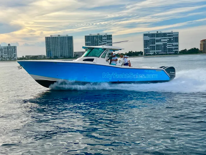 The Office Yacht Photos Pics 2012 Grady-White Canyon 366 boat cruising on water with cityscape background.