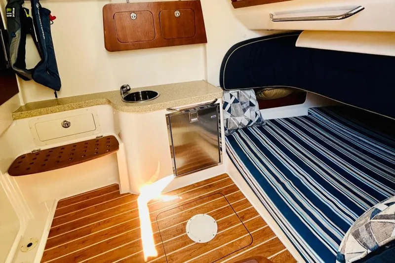 The Office Yacht Photos Pics 2012 Grady-White Canyon 366 cabin interior with striped bedding and compact kitchenette.