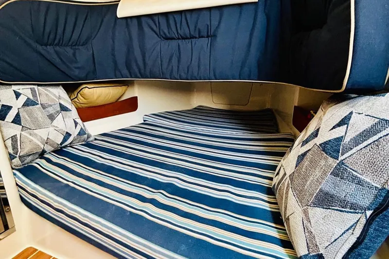 The Office Yacht Photos Pics Cozy cabin interior of 2012 Grady-White Canyon 366 with striped bedding and patterned cushions.