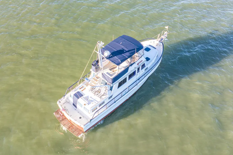 Cheers Yacht Photos Pics Aerial view of 1989 Grand Banks 46 Classic yacht cruising on calm waters.