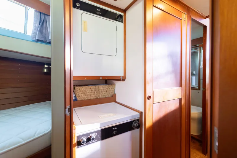 Cheers Yacht Photos Pics Laundry area inside 1989 Grand Banks 46 Classic yacht with wood paneling and compact washer-dryer.