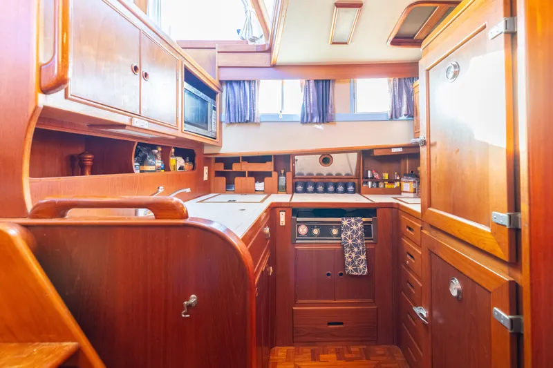 Cheers Yacht Photos Pics Galley kitchen in 1989 Grand Banks 46 Classic yacht, featuring wood cabinetry and modern appliances.