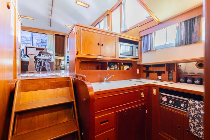 Cheers Yacht Photos Pics 1989 Grand Banks 46 Classic yacht interior with wooden cabinetry and modern kitchen amenities.