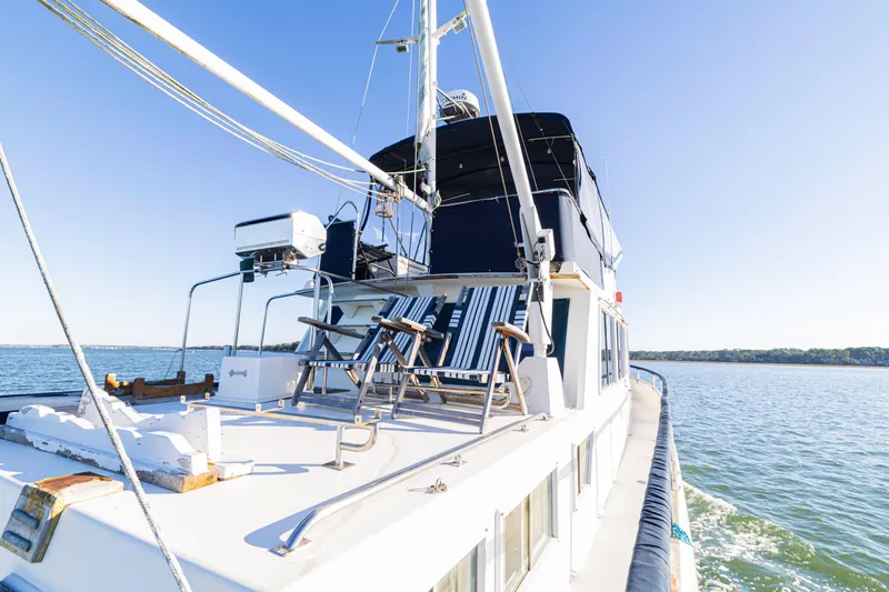 Cheers Yacht Photos Pics 1989 Grand Banks 46 Classic yacht on calm water, featuring deck chairs and clear blue sky.