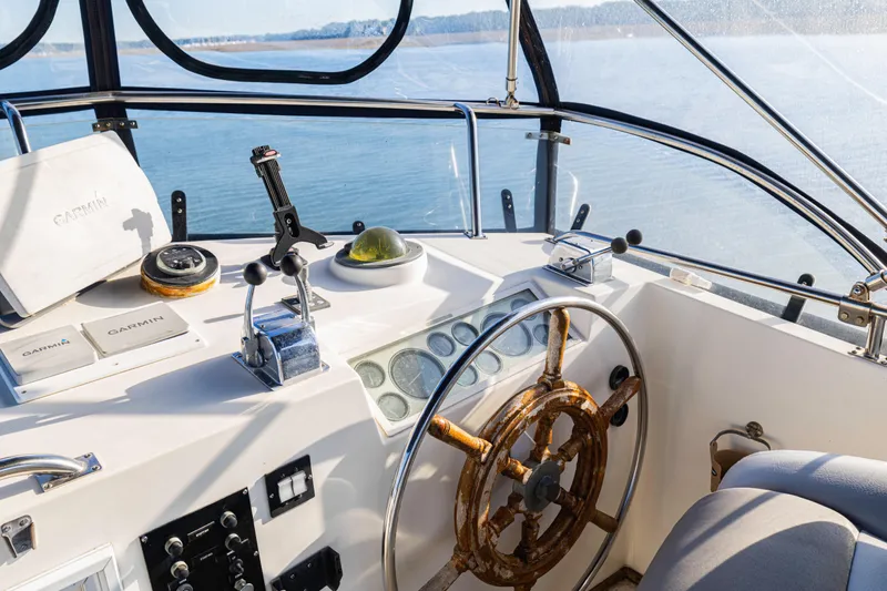 Cheers Yacht Photos Pics Helm of 1989 Grand Banks 46 Classic yacht with navigation equipment and wooden wheel.