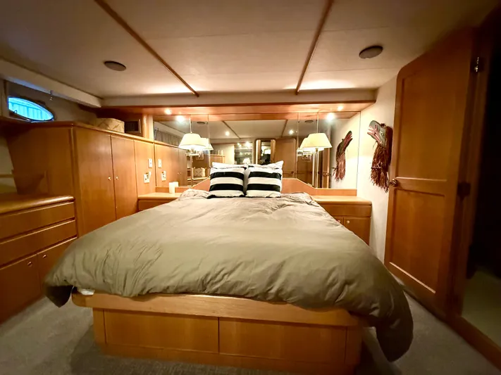 Cavileah Yacht Photos Pics Luxurious bedroom in 1997 West Bay Sonship 58 Pilothouse yacht with wood furnishings and cozy bedding.