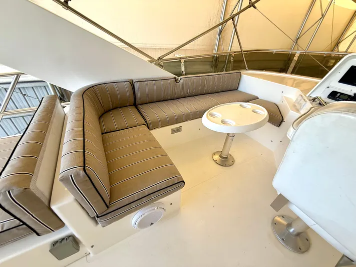 Cavileah Yacht Photos Pics 1997 West Bay Sonship 58 Pilothouse interior with striped seating and round table.