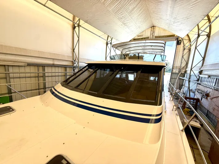 Cavileah Yacht Photos Pics 1997 West Bay Sonship 58 Pilothouse yacht in covered storage, showcasing sleek design and spacious deck.