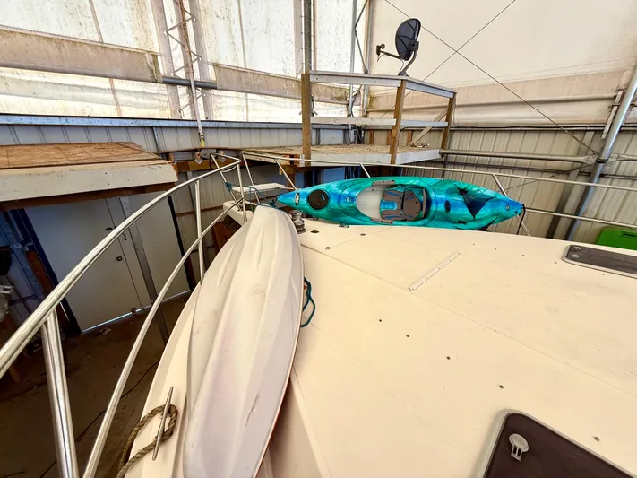 Cavileah Yacht Photos Pics 1997 West Bay Sonship 58 Pilothouse with kayaks on deck in a covered storage area.