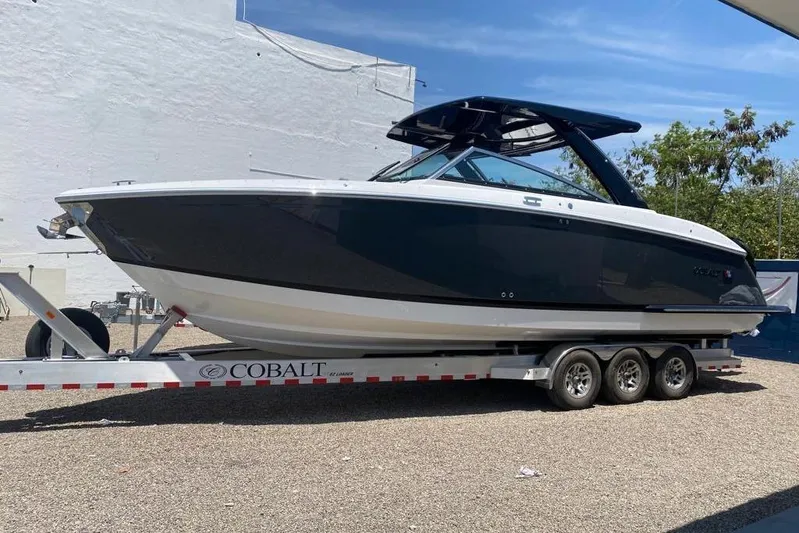 Casa - 2023 Cobalt R33 Ob @ Vallarta Yacht Photos Pics 2023 Cobalt R33 Outboard boat on trailer, sleek design, parked outdoors.