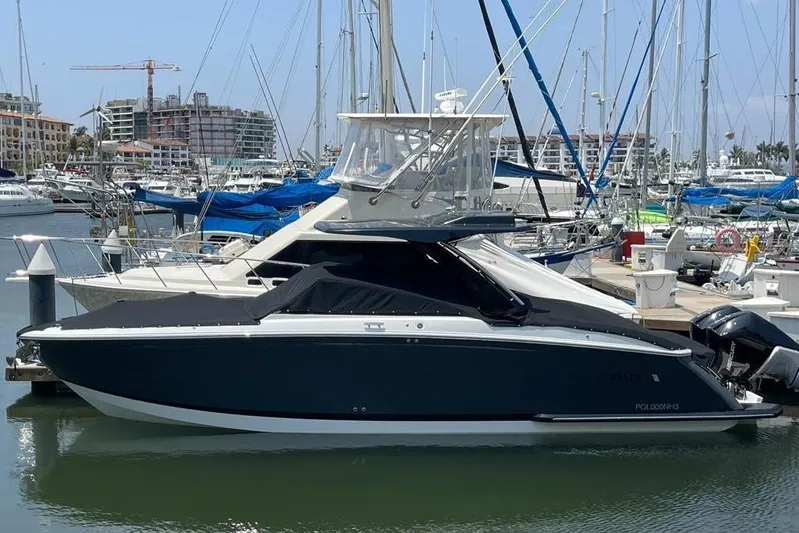 Casa - 2023 Cobalt R33 Ob @ Vallarta Yacht Photos Pics 2023 Cobalt R33 Outboard boat docked in a marina, surrounded by sailboats.