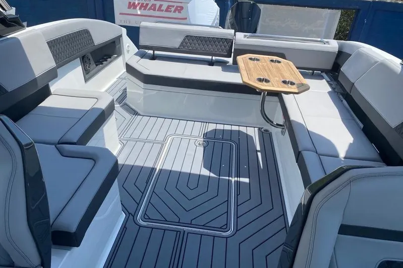 Casa - 2023 Cobalt R33 Ob @ Vallarta Yacht Photos Pics 2023 Cobalt R33 Outboard boat interior with gray seating and wooden table.