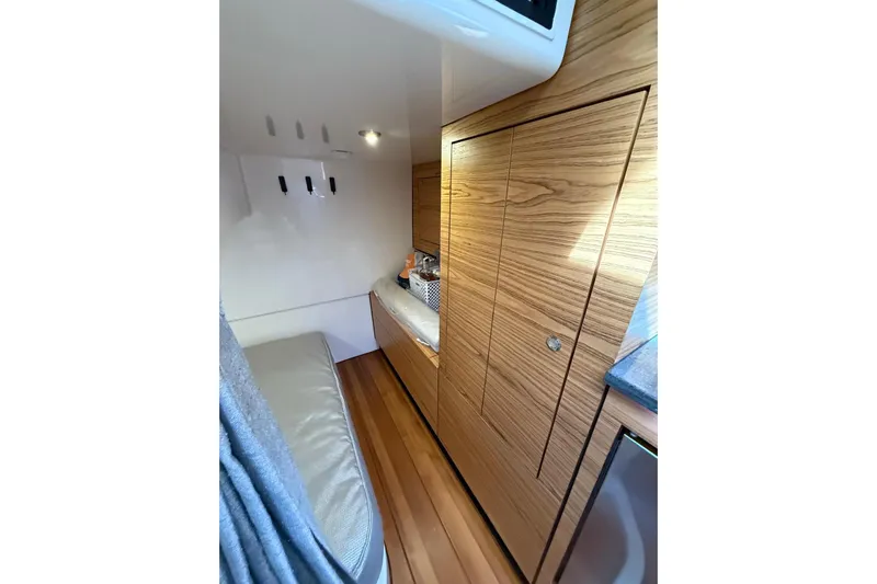  Yacht Photos Pics 2024 Boston Whaler 405 Conquest cabin interior with wood paneling and seating.