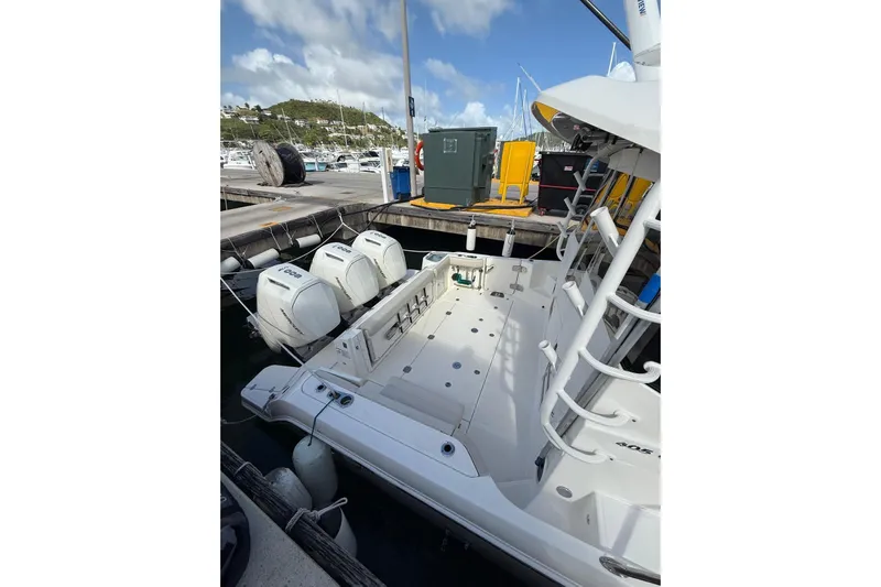  Yacht Photos Pics 2024 Boston Whaler 405 Conquest docked, showcasing powerful outboard engines and spacious deck.