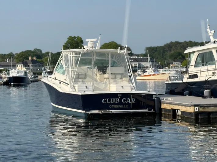 Club Car Yacht Photos Pics 1999 Cabo 31 Express boat docked in a marina, calm water, clear sky.